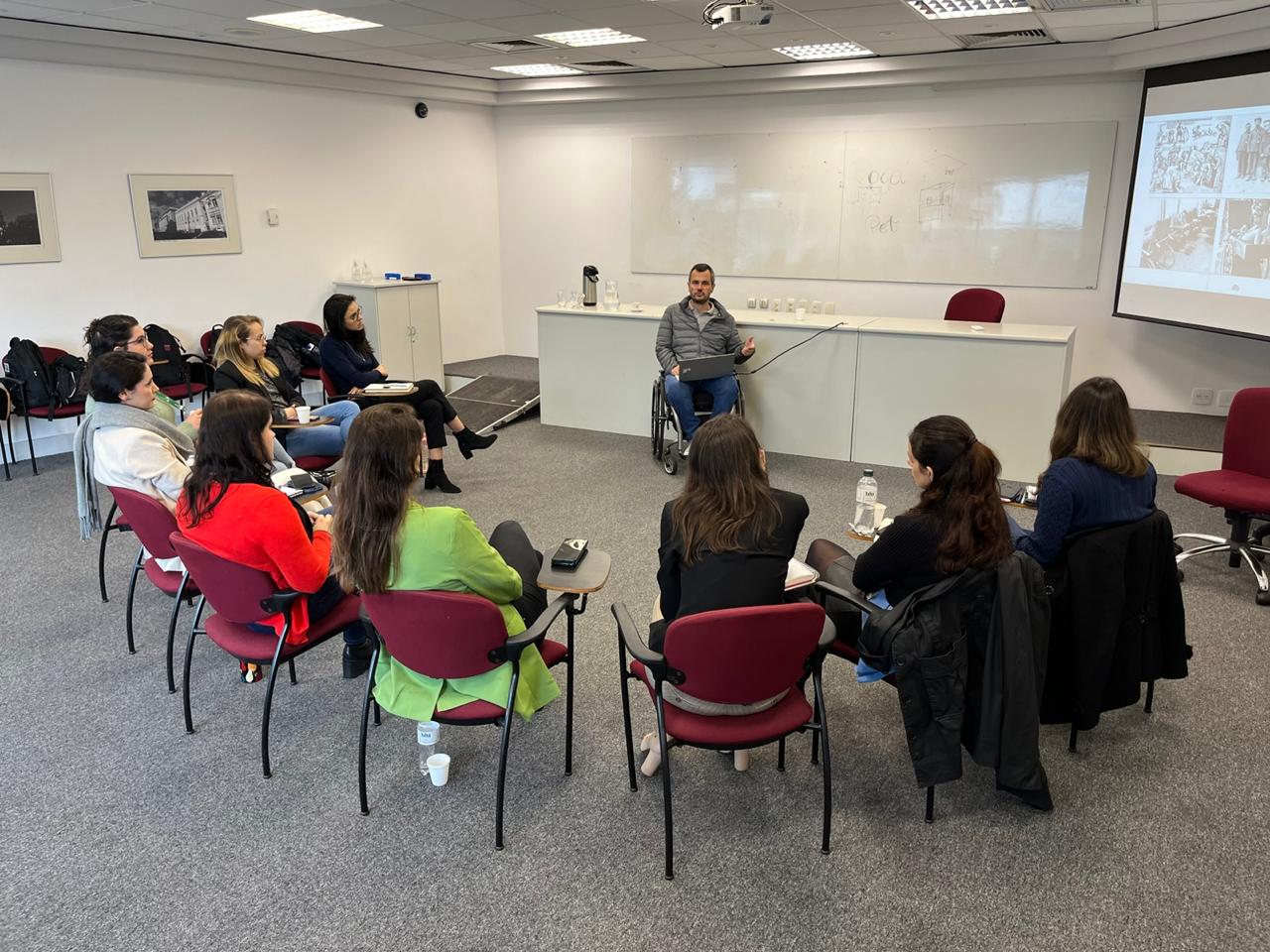 Facilitador conduzindo roda de conversa com participantes em sala de treinamento
