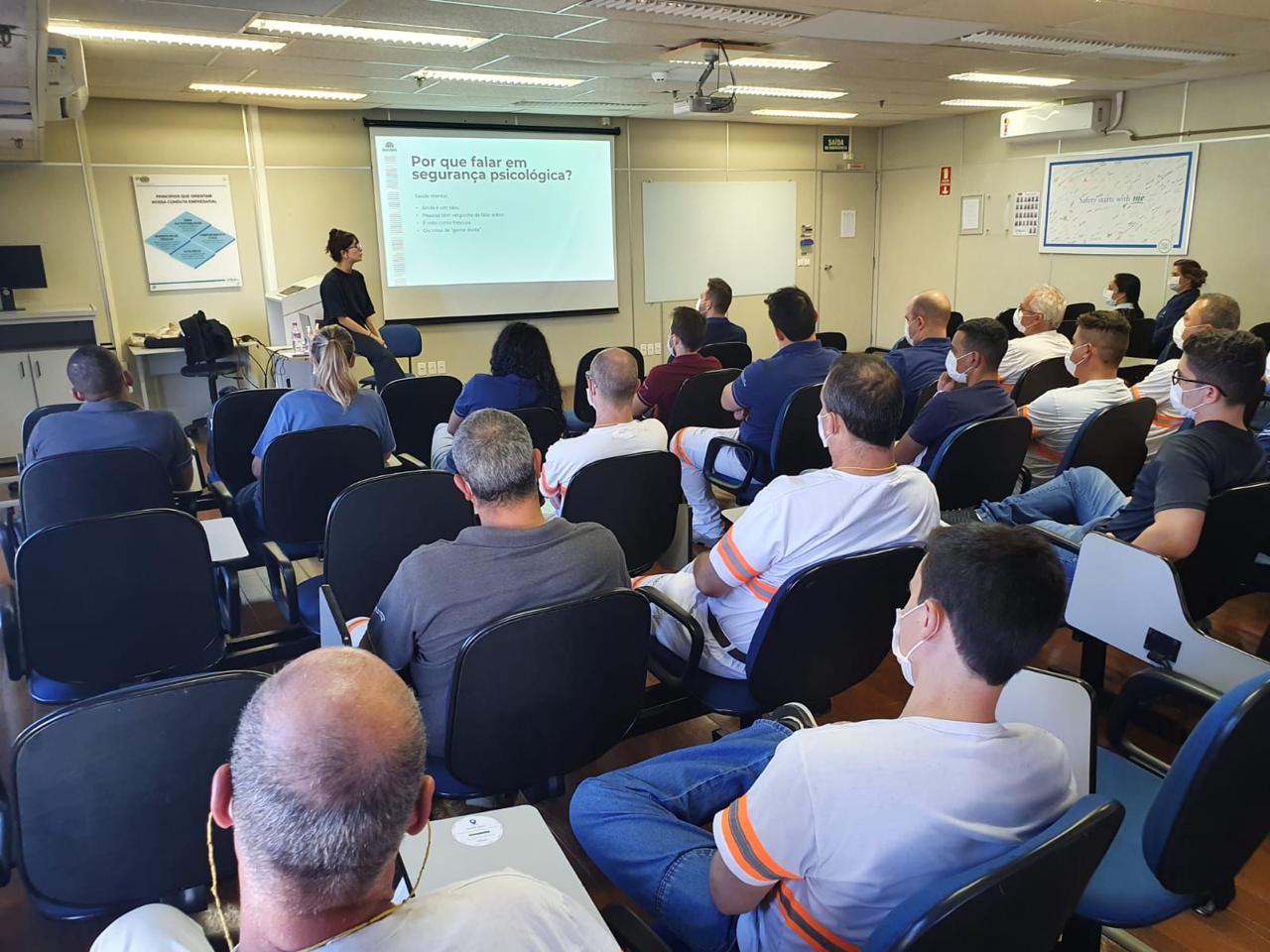 Facilitadora conduzindo sessão sobre segurança psicológica em ambiente industrial